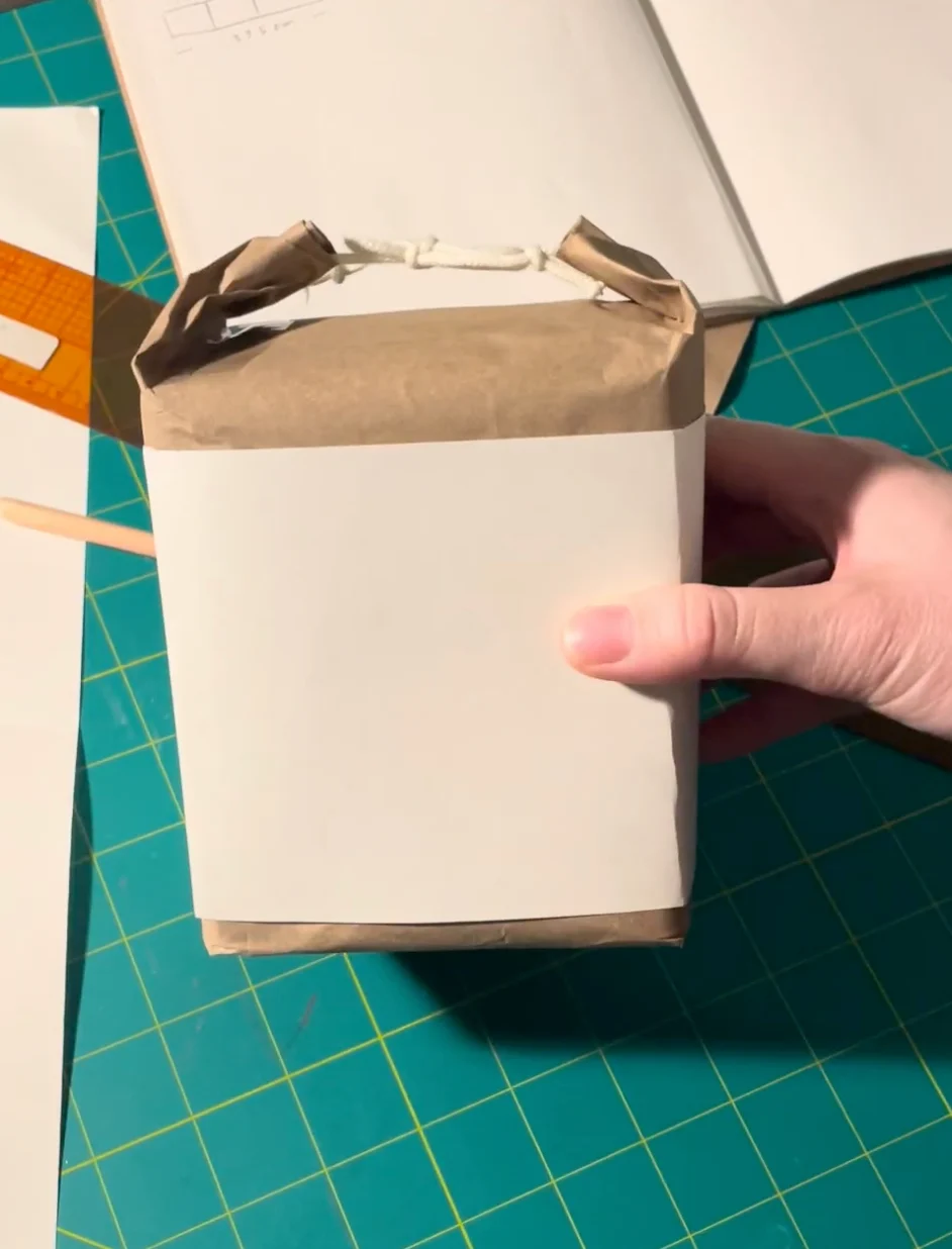 The first packaging idea: the box wrapped in brown paper like a lunch bag, tied with cord