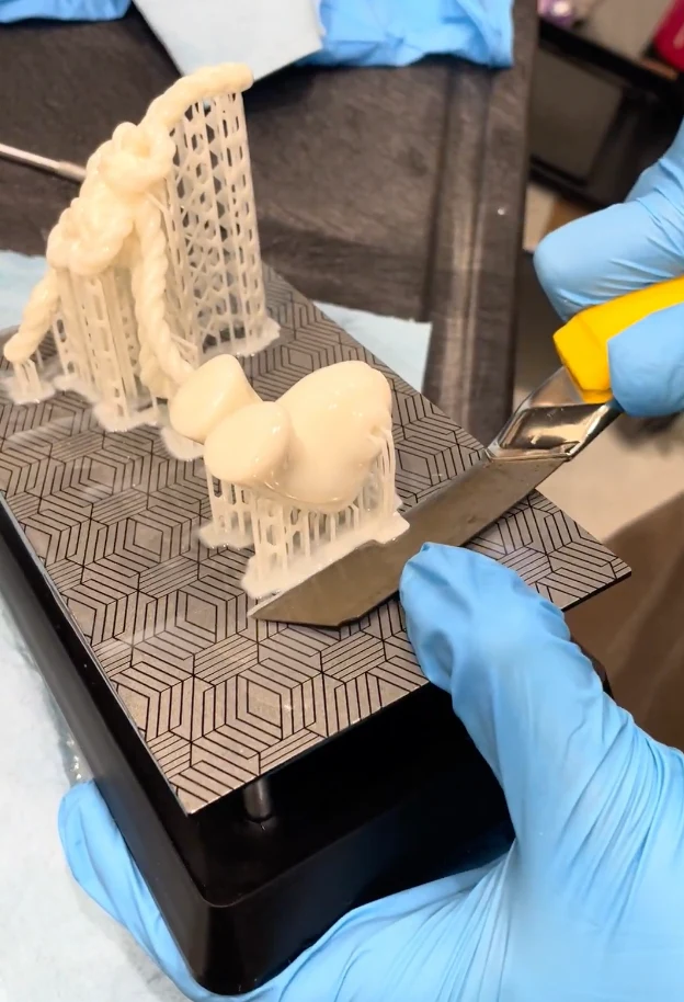 Scraping freshly printed resin figurine parts and their supports off the build plate