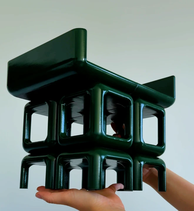 The finished shelf in dark green, held up in two hands